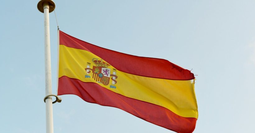 Photo by Max Harlynking the spanish flag is flying high in the sky