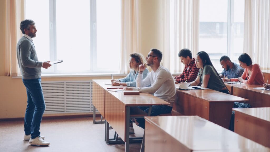 Teacher instructing students in a classroom lecture.