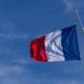 French national flag waving on flagpole under a bright clear blue sky in Le Pouliguen.
